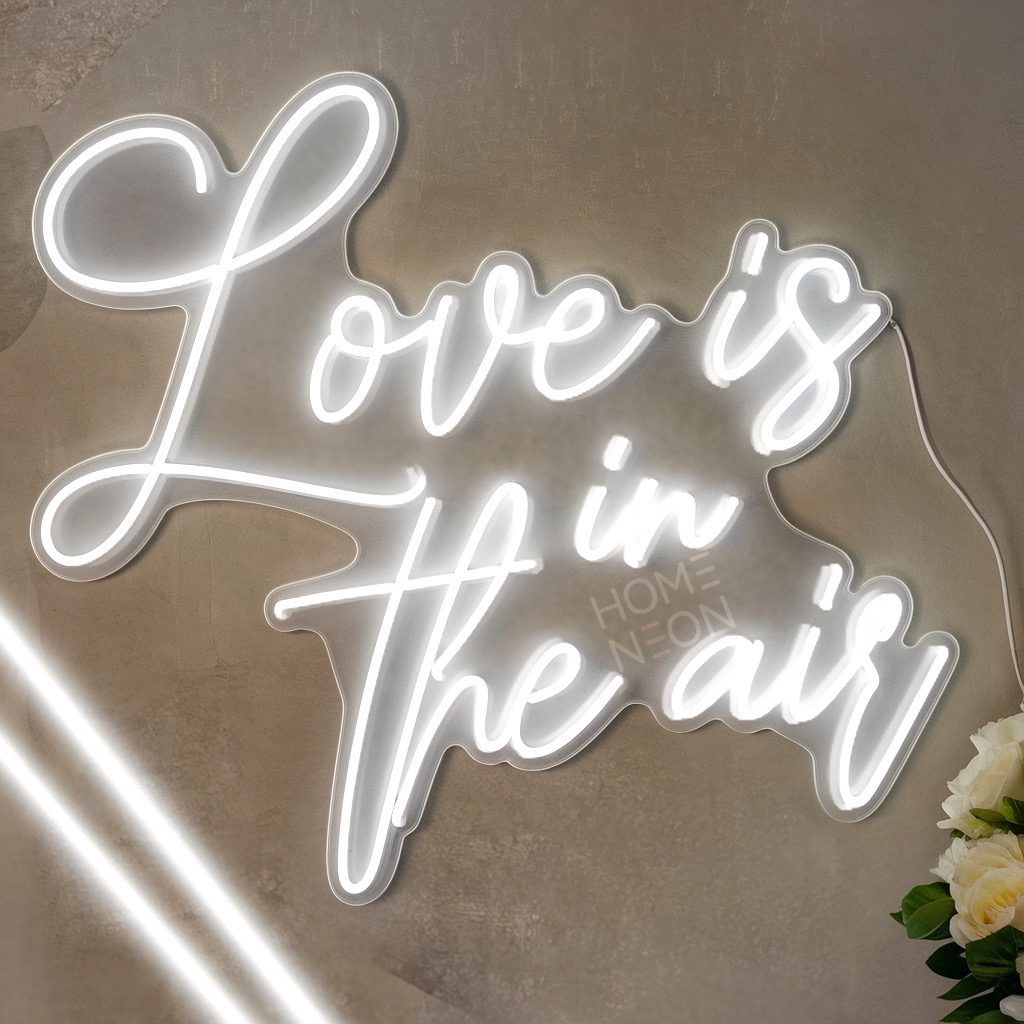 Неоновая вывеска с надписью Love is in the air